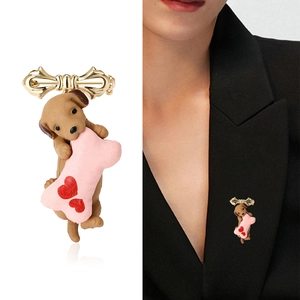 Cartoon puppy brooch with pink bone and gold bow on black suit jacket for decoration