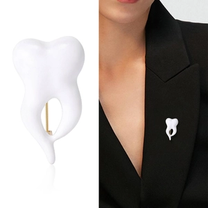 Minimalist white enamel tooth crown brooch pin for dentist on a black blazer jacket