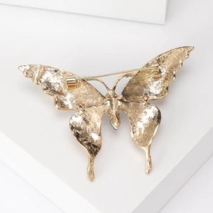 Vue arrière de la broche papillon dorée avec texture étoile et épingle de sûreté
