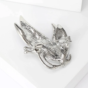 Broche en forme d'oiseau argentée en alliage avec fermoir de sécurité sur fond blanc