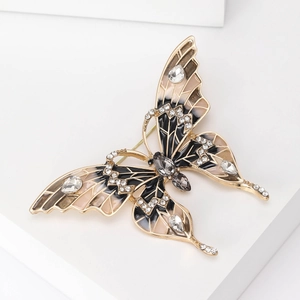 Vue détaillée de la broche papillon en émail avec placage à l'or et cristaux brillants