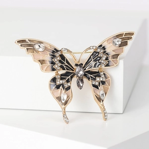 Détail macro d'une broche papillon en émail avec cristaux sur support blanc pur