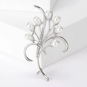 Dettaglio macro di elegante spilla a fiore con perle bianche e strass brillanti