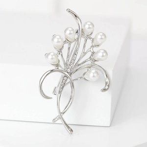 Elegante spilla a fiore con petali di perle bianche e steli di strass argento su podio