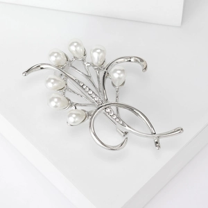 Dettaglio della spilla a fiore argento con perle radiose e strass luccicanti