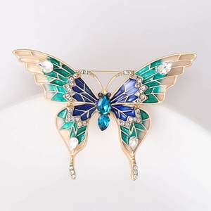 Détail de la broche papillon en émail coloré ornée de cristaux et finition dorée