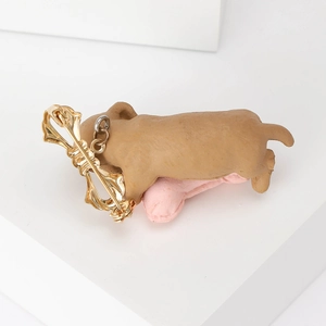 Cute puppy dog brooch with pink bone detail on a white minimalist display stand