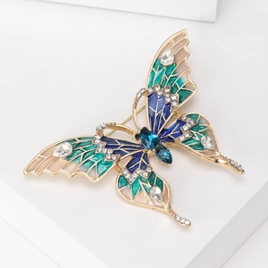 Détail macro d'une broche papillon en émail coloré avec des strass et pierres incrustés