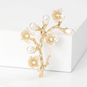 Spilla elegante a ramo dorato con perle e petali iridescenti su base bianca