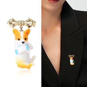 Cute Corgi dog brooch with golden bow and enamel finish shown on suit lapel