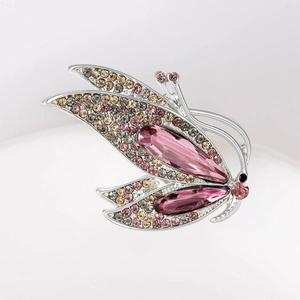 Gros plan sur la broche papillon avec cristaux roses et strass scintillants