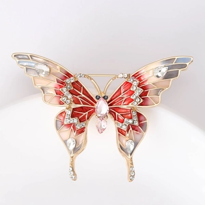 Détail d'une broche papillon en émail rouge avec cristaux et pierres roses