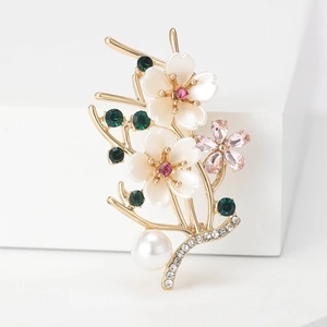 Elegant gold flower branch brooch with pearl and colorful crystals on white stand