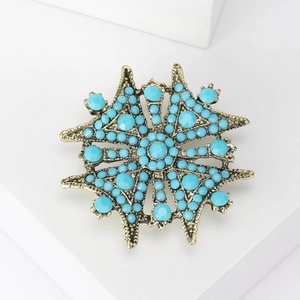 Gros plan de la broche étoile bohème avec perles turquoise sur métal bronze antique