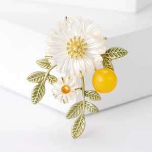 Vue macro d'une broche marguerite avec pétales de nacre et détails de feuilles