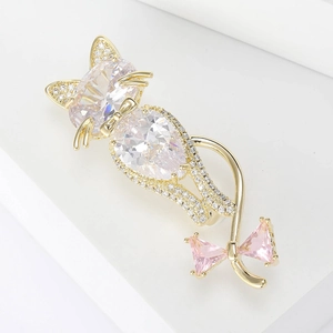 Macro detail of cat brooch with sparkling zircon stones and a pink crystal bow