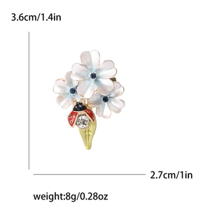 Broche fleurie bleu clair avec coccinelle et cristaux étincelants élégants