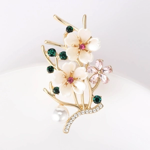 Macro shot of elegant floral brooch with pearl, pink gemstone, and gold branch details