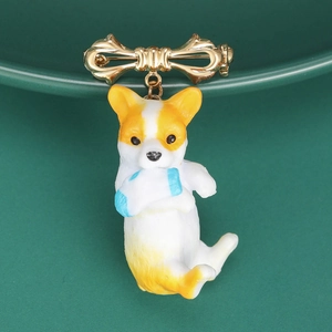 Detail of cute corgi dog pendant and golden bowknot brooch on green ceramic base