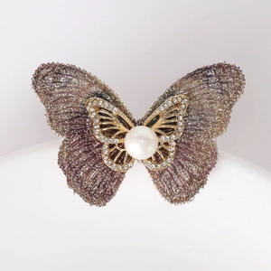 Vue détaillée de la broche papillon en tissu avec perle centrale et zircons incrustés
