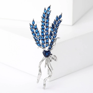 Macro detail of wheat ear brooch with dark blue marquise crystals and heart-shaped stone