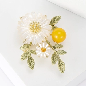 Broche fleur marguerite élégante avec pétales blancs, feuilles vertes et épingle dorée