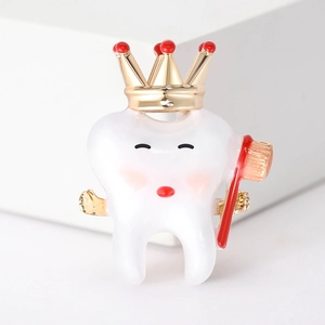 Macro detail of a cartoon tooth brooch with golden crown and toothbrush accessories