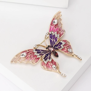 Détail macro de la broche papillon en émail avec dégradé rose et strass incrustés