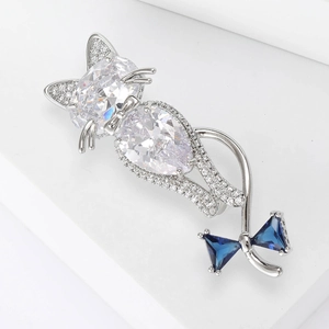 Detailed macro view of the silver cat brooch featuring zircon stones and a blue crystal bow