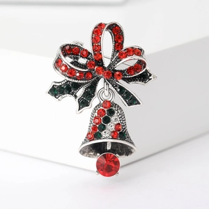 Detail van kerstbel broche met rode strik groene bladeren en gekleurde strass-steentjes