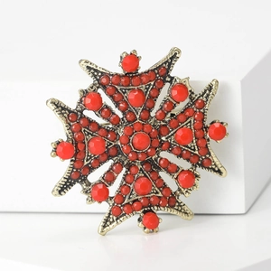 Broche croix de Malte vintage dorée avec perles rouges sur socle blanc géométrique