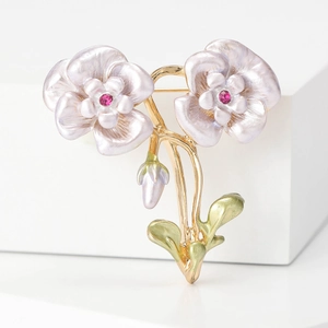Elegante Kamelien-Brosche mit perlvioletten Blütenblättern und Kristallen auf Goldzweig