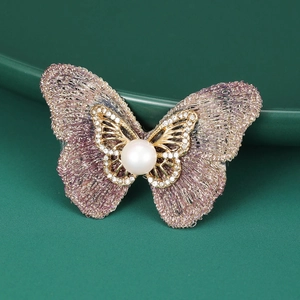 Détail de la broche papillon avec perle centrale et tissu tissé violet élégant
