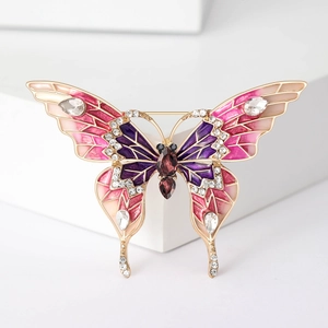 Détails des ailes en émail rose et des cristaux brillants sur la broche papillon