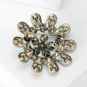 Broche tournesol dorée vintage avec pierre turquoise montrant le fermoir