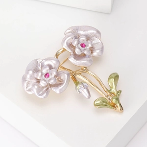 Detail der Kamelien-Brosche mit lavendelfarbenen Perlenblüten und rosa Strass