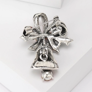 Achteraanzicht van vintage zilveren kerstbel broche met strik en een naaldsluiting