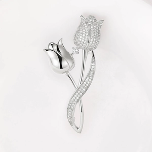 Macro view of crystal paved tulip brooch with polished silver finish and sparkling stones