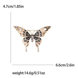 Broche papillon dorée avec émail noir et beige et strass sur fond blanc épuré