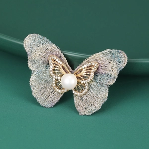 Vue macro détaillée d'une élégante broche papillon en tissu tissé avec perle et strass
