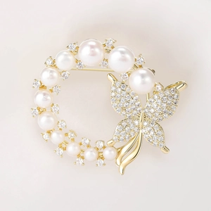 Detailed macro view of the gold butterfly brooch with freshwater pearls and zircons