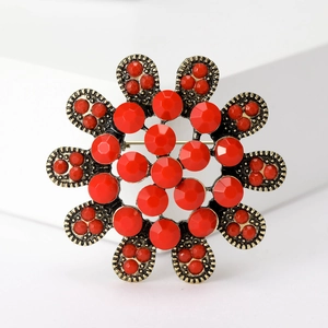 Détail de la broche fleur rétro avec cristaux rouges taillés sur socle doré