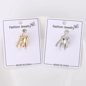 Dettaglio delle spille a forma di dente in oro e argento con strass scintillanti