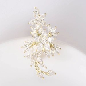 Vue macro des zircons marquise et détails floraux dorés sur une broche de luxe