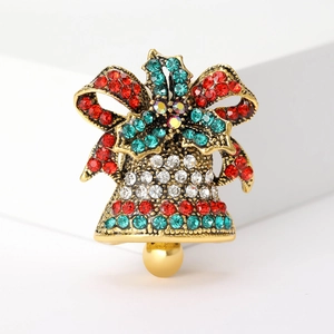 Close-up of vintage Christmas bell brooch with red bow and sparkling rhinestones