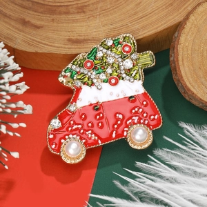 Weihnachtsauto-Brosche mit Strasssteinen und Perlenrädern auf festlichem Hintergrund