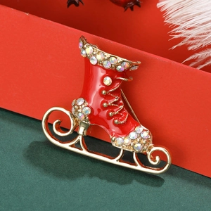 Detalle de un broche de patín de hielo navideño con esmalte rojo y diamantes de imitación