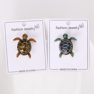 Close-up of vintage turtle brooches with rhinestones on retail display cards