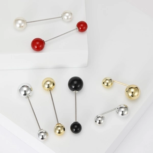 Lot de sept broches à boules minimalistes et épingles sur présentoir géométrique blanc