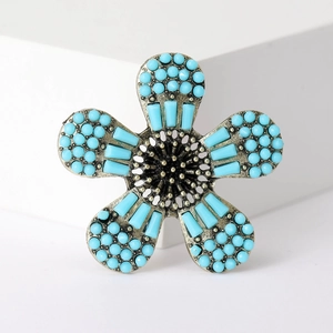 Makroaufnahme einer Vintage Silber Blumenbrosche mit blauen Perlen im Boho-Stil Details